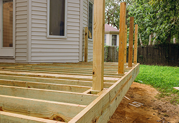 New deck frame installation with pressure-treated lumber in Newhall backyard